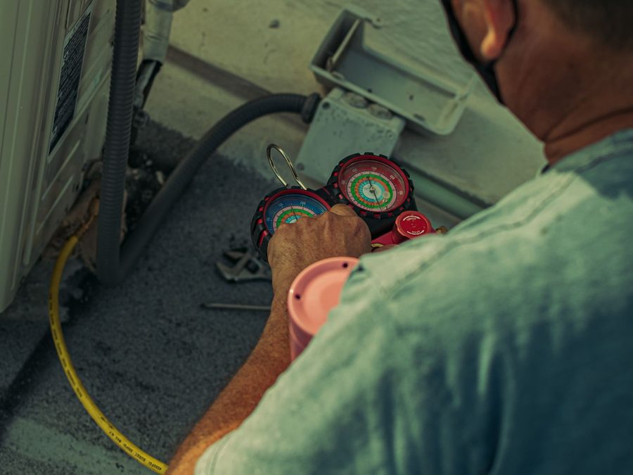 Técnico de refrigeração medindo pressão do sistema