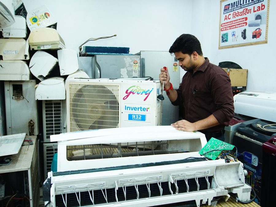 Técnico fazendo manutenção em ar condicionado